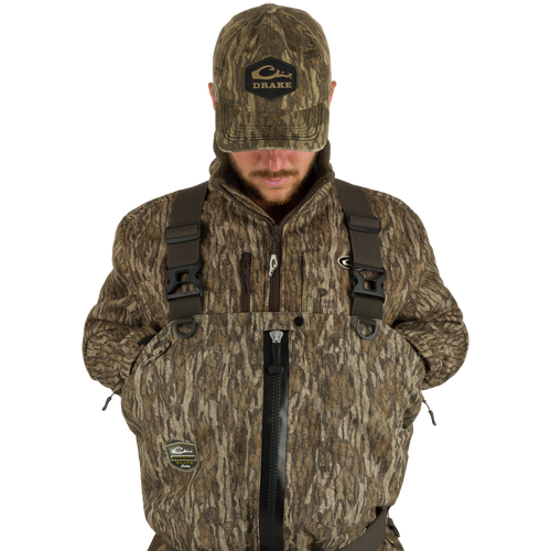 Uninsulated Guardian Elite HND Front Zip Waders - Habitat: A man in a camouflage outfit wearing a jacket and hat, standing in the marsh, ready for outdoor hunting.