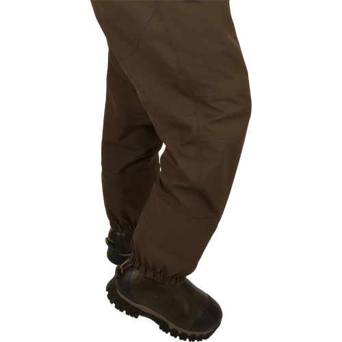 Uninsulated Guardian Elite HND Front Zip Waders - Habitat: Person wearing brown pants and boots, standing in marsh, ready for outdoor hunting.