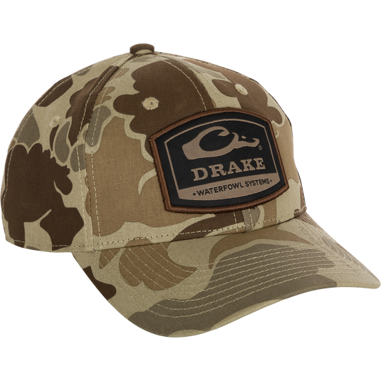 A 6-Panel Badge Cap with a camouflage pattern and logo, perfect for outdoor enthusiasts. Made of cotton blend panels, it features a secure fit with a rear snap closure.