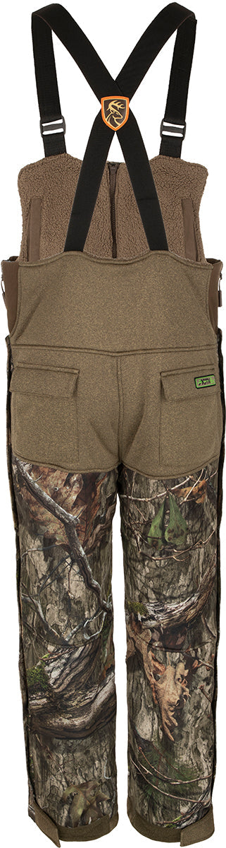 A person wearing camouflage shorts, part of the Youth Silencer Bib With Agion Active XL - Realtree collection from Drake Waterfowl.