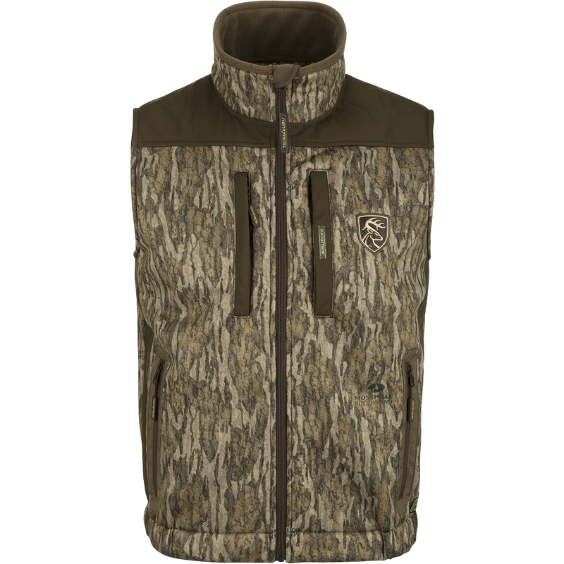 Standstill Windproof Vest with Agion Active XL®: A camouflage jacket with a logo of a deer, perfect for mid-to-late season hunting. Features include scent control technology, zippered pockets, and a safety harness pass-through opening. Ideal for layering or wearing over a mid-layer.