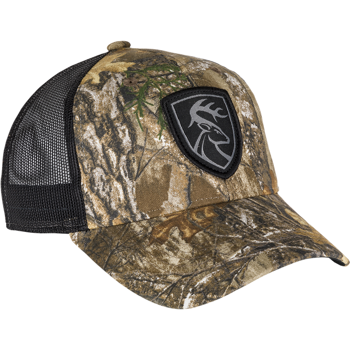 A black and brown camouflage hat with a logo patch of a deer head. Made with 100% cotton twill and breathable mesh on the back. Features a snap closure.