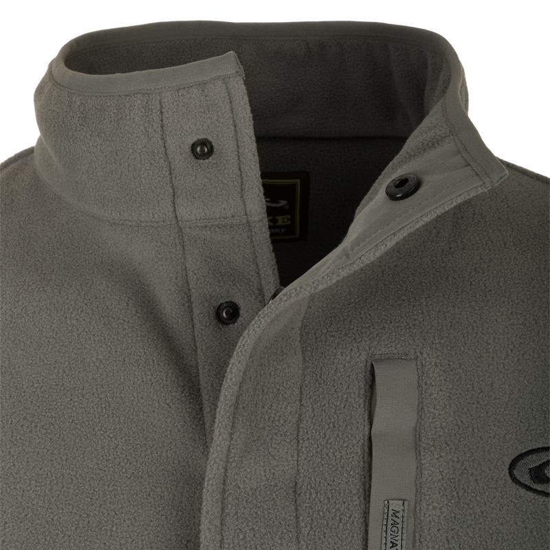 A close-up of the Camp Fleece Pullover 2.0, a lightweight poly-fleece jacket with a neck snap closure and vertical Magnattach™ chest pocket. Perfect for layering in Spring or Fall.
