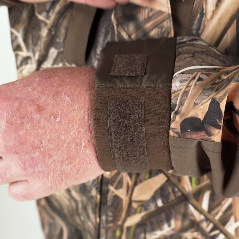 A close-up of a person's arm wearing the EST Heat-Escape Full Zip 2.0 - Realtree. The waterproof fabric and underarm vents help prevent overheating during warm weather hunts.