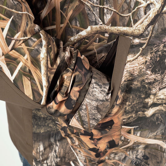 A person wearing the EST Heat-Escape Full Zip 2.0 - Realtree, a camouflage shirt, outdoors.