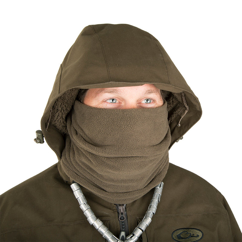 A person wearing a Guardian Elite Flooded Timber Insulated Jacket with a mask and hood, designed for hunters in wet conditions.