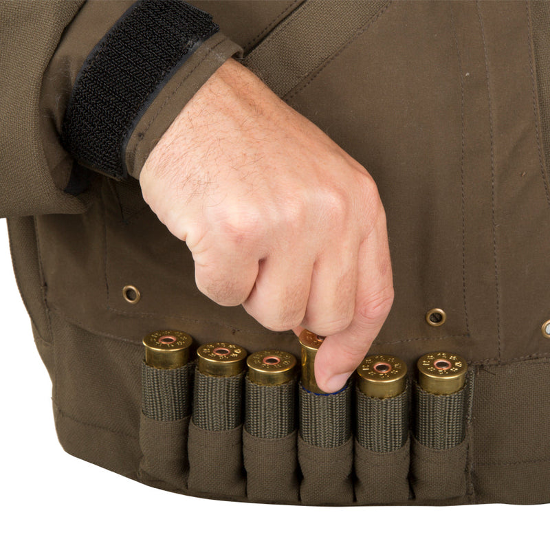 A hand holding a bullet in a belt, showcasing the Guardian Elite Flooded Timber Insulated Jacket by Drake Waterfowl.