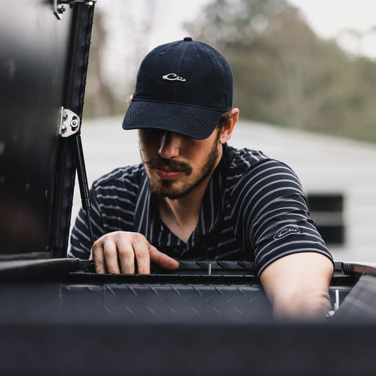 A man in the Drake Performance Striped Polo. Offers 4-Way Stretch, moisture-wicking, and UPF Sun Protection for versatile comfort in hunting and casual wear.