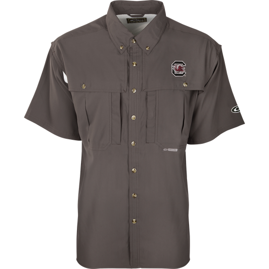 South Carolina S/S Flyweight Wingshooter: A grey shirt with a logo, designed for warm-weather outdoor activities. Features include vented back design, quick-drying fabric, UPF 50+ sun protection, and multiple pockets.