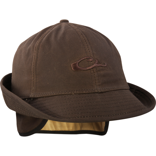 A brown Wax Canvas Jones Hat with a logo, fold-down ear flaps, and 2" shape-able brim. Features quilted Thinsulate® insulation for heat retention.