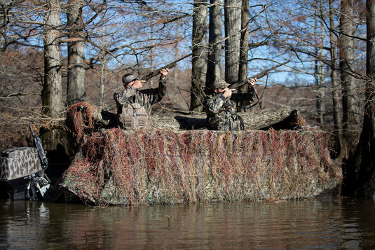 A group of men in camouflage on a boat with a Ghillie Boat Blind with No-Shadow Dual Action Top.