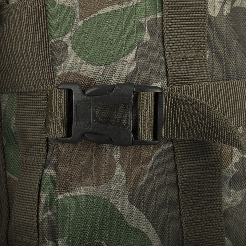 Non-Typical Rucksack: A close-up of a bag with a black plastic buckle on a fabric surface. Versatile pockets, MOLLE loops for customization, and adjustable straps for optimal storage and accessibility. Perfect for hunting necessities.