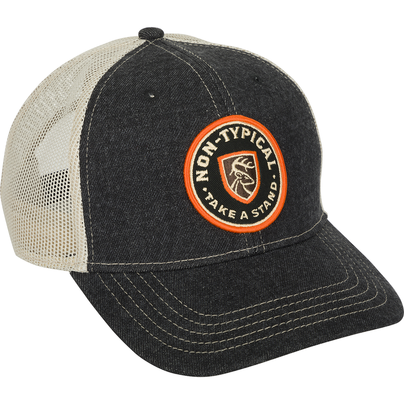 A black and white baseball cap with a logo patch on the front and a mesh back. Made with 100% cotton twill and adjustable snap closure.