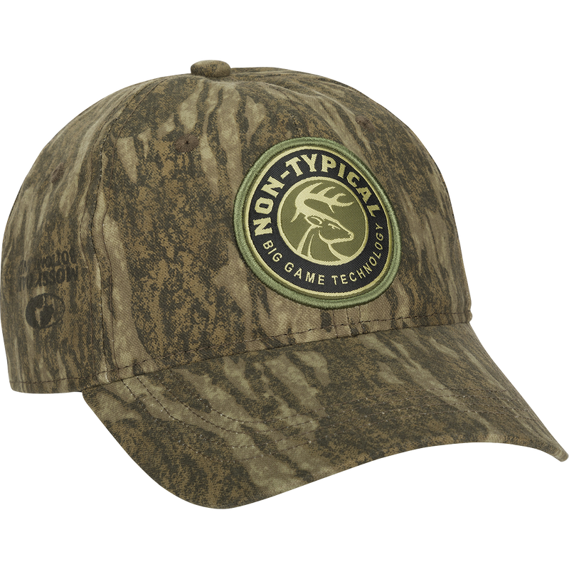 A Big Game Technology Patch Camo Twill Cap with a logo on it, offering full camo concealment and a comfortable 60% cotton/40% polyester construction. Features a six-panel design and adjustable snap closure.