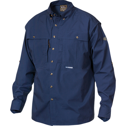 A blue long-sleeved shirt with a brown and white logo, front and back ventilation, oversized chest pockets, and a vertical zippered pocket. StayCool™ fabric keeps you cool and dry. Perfect for outdoor activities or casual office wear.
