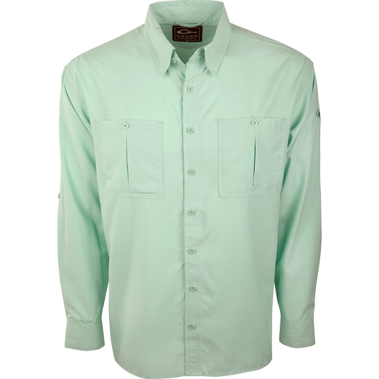 A close-up of the Flyweight Shirt with Vented Back L/S. A green button-up shirt made of ultra-lightweight polyester. Features include Sol-Shield™ UPF 50+ sun protection, vented mesh back, and horizontal chest pockets. Quick-drying, moisture-wicking, and breathable.