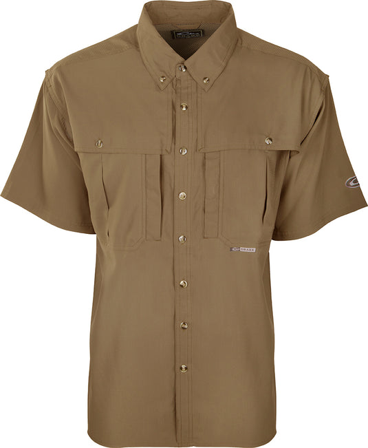 A close-up of the Youth S/S Flyweight Wingshooter's Shirt, a brown button-up shirt with a collar and short sleeves. Lightweight, quick-drying, and easy to clean, this shirt is perfect for active kids. Features include a Magnattach left chest pocket, front and back heat vents, a sun blocker extension collar, and a mesh back for air circulation. Wrinkle-resistant EasyCare™ fabric ensures low maintenance. Ideal for school, play, and outdoor adventures.