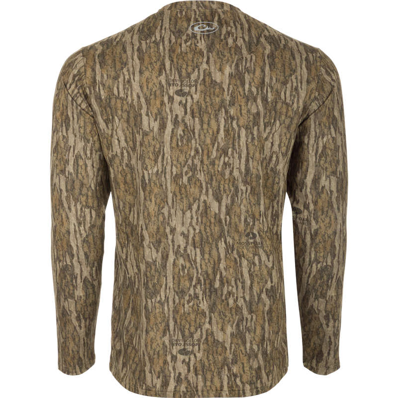 A Youth EST Camo Performance Long Sleeve Crew shirt with a tree pattern, offering comfort and protection for outdoor activities. Made of 92% Polyester/8% Spandex with 4-Way Stretch and Shield 4 treatments.