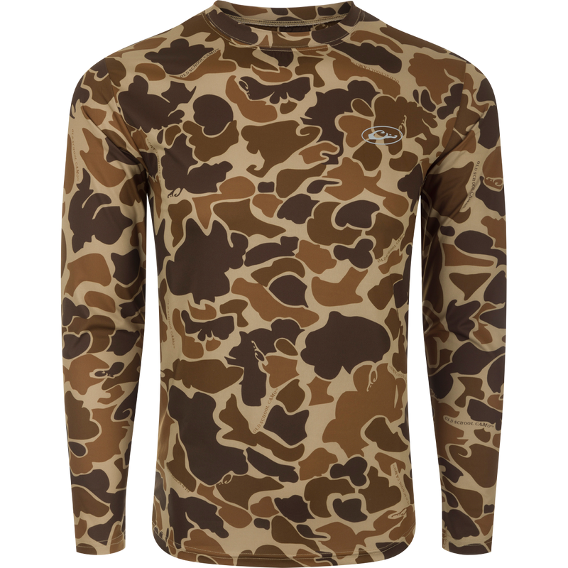 A youth long sleeve crew shirt with a camouflage pattern, offering comfort and protection for outdoor activities. Made of 92% Polyester/8% Spandex with 4-Way Stretch capabilities. Features Shield 4 Sun™ UPF 50+ Treatment, Shield 4 Coolant™ Treatment, Shield 4 Odor™ Treatment, and Shield 4 Stains™ Treatment.