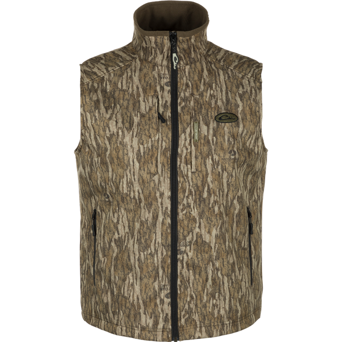 MST Windproof Softshell Vest with camouflage pattern, Magnattach™ chest pocket, and zippered pockets for secure storage. Customizable fit with drawcord waist. Superior comfort and breathability with 4-way stretch and grid-fleece collar lining. Expert-level functionality for hunting and outdoor activities.