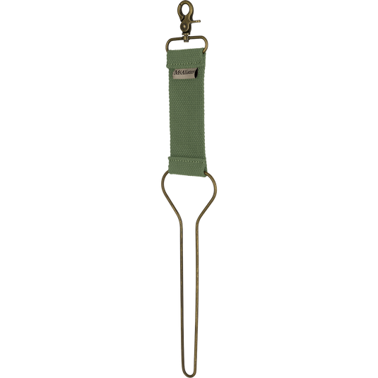 McAlister Game Bird Totes: Green cloth strap with a hook, gold bars, green fabric strap with a metal loop, close-up of a green rug, metal hook, and metal object. 100% cotton webbing, solid metal hardware, brass clip.
