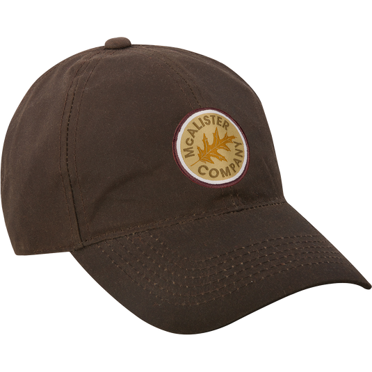 A McAlister Waxed Cotton Baseball Cap with embroidered logo. Features 10 oz waxed cotton and adjustable Velcro closure. Ideal for hunting and outdoor activities.