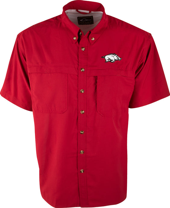 A red shirt with a pig logo, perfect for warm-weather outdoor activities. Made of ultra-lightweight polyester, it dries quickly and wicks moisture away. Features include a vented mesh back and chest pockets with velcro closures. Arkansas logo embroidered on left chest.