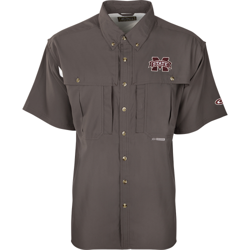 A close-up of the Mississippi State S/S Flyweight Wingshooter shirt with a logo on it, featuring a vented back design, quick-drying fabric, and multiple pockets for outdoor activities.
