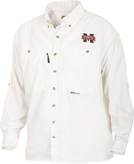 A white button-up shirt with a logo, perfect for Game Day. Breathable and quick-drying with front and back ventilation. Features include oversized chest pockets, a zippered pocket, and a Magnattach pocket. Mississippi State Wingshooter's Shirt L/S.