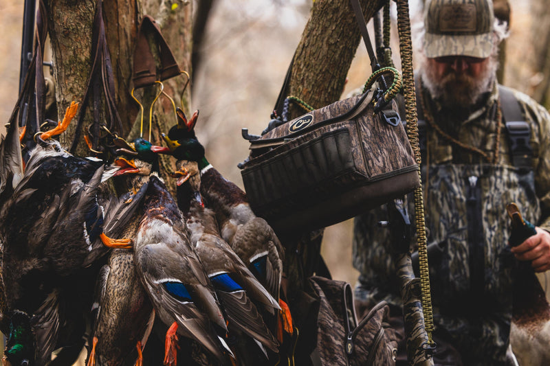 Hunter with harvested mallards, featuring the Tree Hugger Shoulder Bag, showcasing its durable, water-resistant design and spacious storage for hunting essentials.