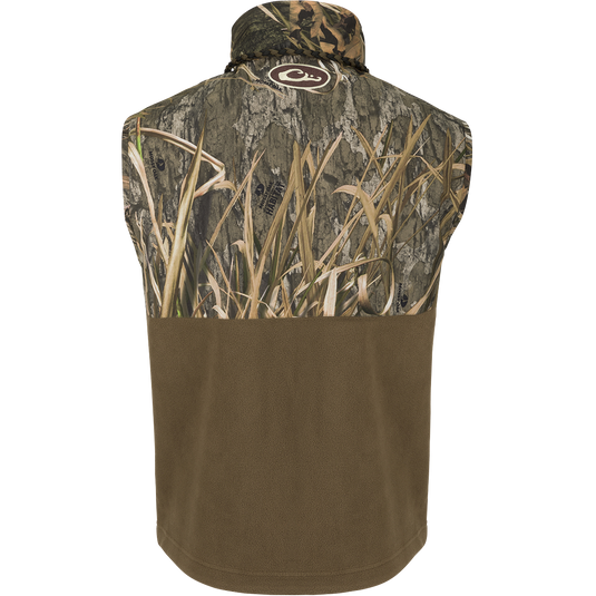Back view of MST Eqwader Vest - Habitat featuring Mossy Oak camouflage and solid brown fleece, with logo at nape, highlighting outdoor functionality and storage pockets.