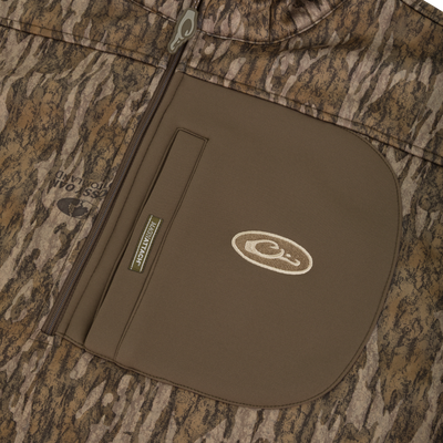 MST Endurance Quarter Zip Jacket with Hood, showcasing Mossy Oak camo fabric, a vertical Magnattach™ chest pocket, and zippered lower pockets for secure gear storage.