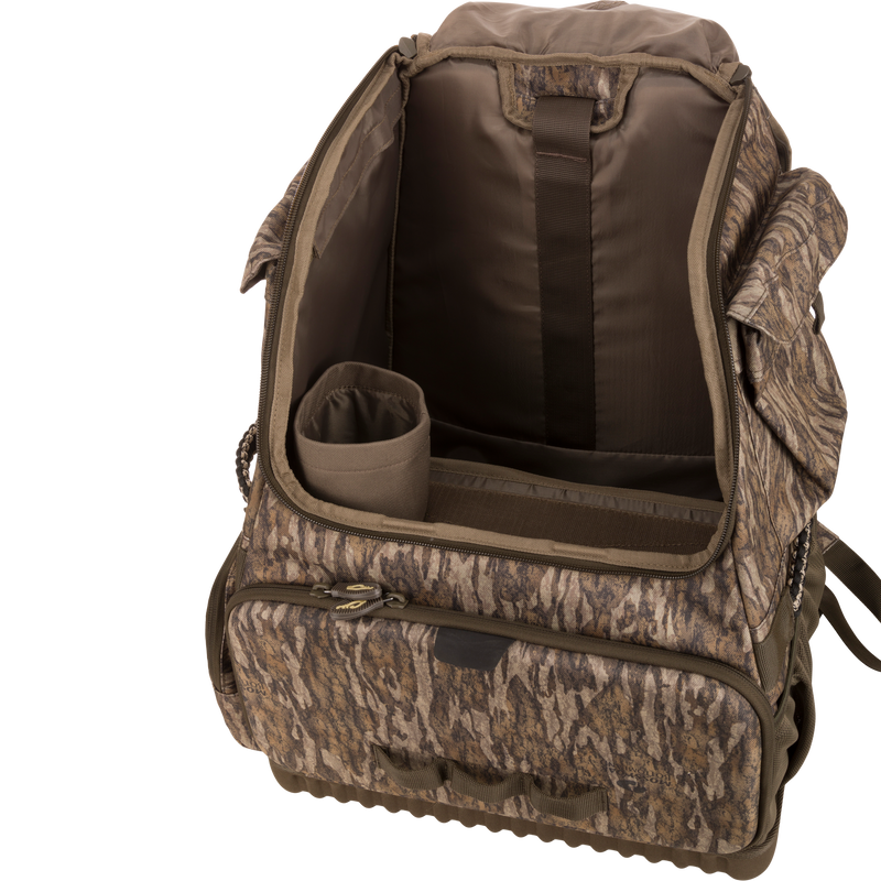 Tree Hugger Timber Pack with open main compartment showing padded dividers, cylindrical insert, various pockets, and exterior zippered front pocket for organized hunting gear storage.