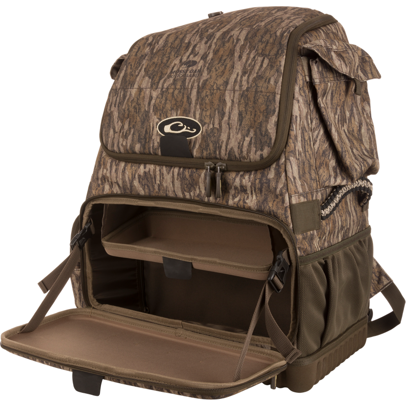 Tree Hugger Timber Pack with Mossy Oak Bottomland print, unzipped to reveal inner shelf and compartments, molded base, side pockets, paracord handles, and detachable strap.