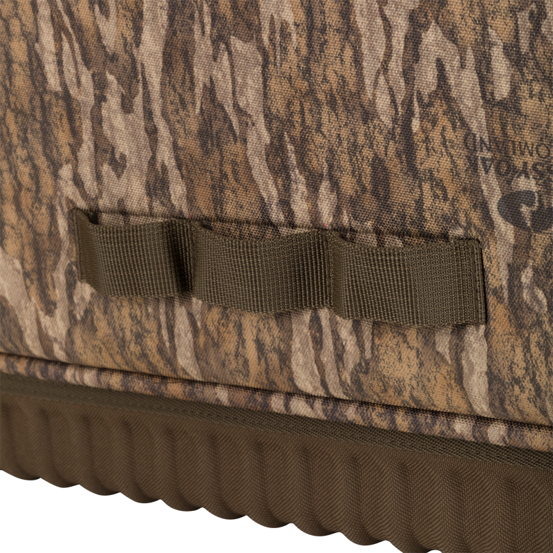 Close-up of the Tree Hugger Timber Pack, showcasing camouflage fabric, MOLLE-style webbing, and a molded, ribbed waterproof bottom for durability.