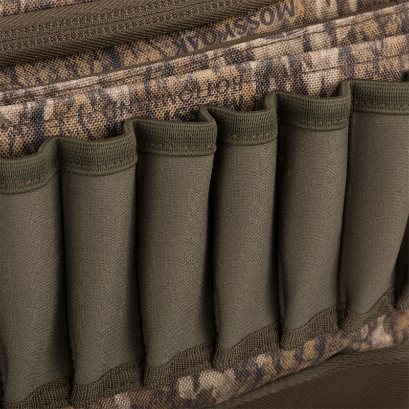 Close-up of Tree Hugger Shoulder Bag’s camouflage panel with empty elastic loops for ammunition, highlighting its functionality for outdoor hunting adventures.