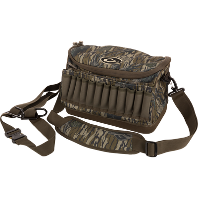 Tree Hugger Shoulder Bag with camo pattern, zip-top, adjustable strap, shell loops, and waterproof bottom, designed for hunting gear storage and outdoor durability.