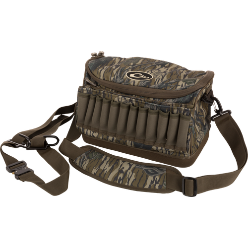 Tree Hugger Shoulder Bag with camo pattern, zip-top, adjustable strap, shell loops, and waterproof bottom, designed for hunting gear storage and outdoor durability.
