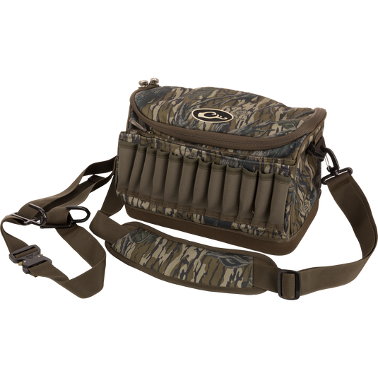 Tree Hugger Shoulder Bag with camo pattern, zip-top, adjustable strap, shell loops, and waterproof bottom, designed for hunting gear storage and outdoor durability.