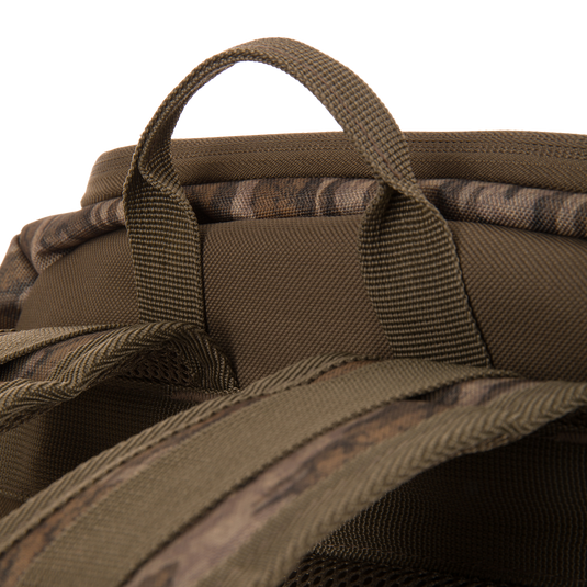 Drake Day Pack's top view with camo-patterned handle and padded shoulder straps, highlighting rugged design for hunting adventures and outdoor durability.