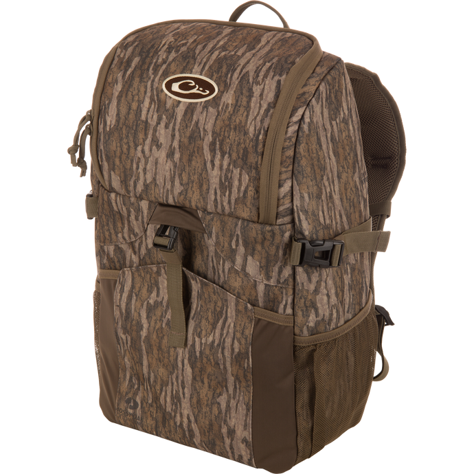 Drake Day Pack, a medium-sized camo backpack with padded straps, side mesh pockets, and a top flap, ideal for outdoor adventures with rugged, water-resistant construction.