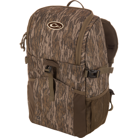 Drake Day Pack, a medium-sized camo backpack with padded straps, side mesh pockets, and a top flap, ideal for outdoor adventures with rugged, water-resistant construction.