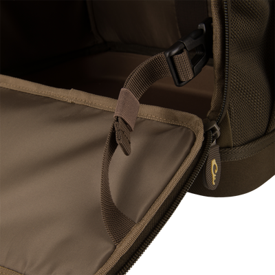 Interior of Tree Hugger Timber Day Pack, showing durable webbing, adjustable strap with buckle, and zipper pull, highlighting rugged construction for outdoor excursions.