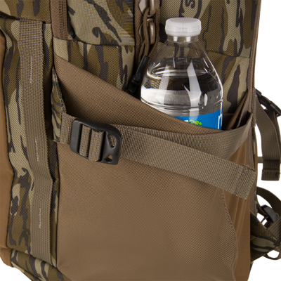 Close-up of the Campus Backpack's heavy nylon webbing pocket holding a water bottle, showcasing its rugged design and quick-release buckle.