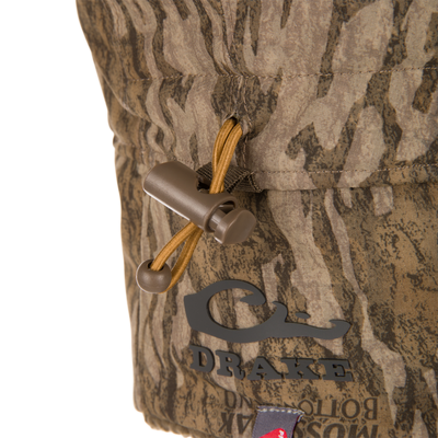 Close-up of a camouflage-patterned fabric pouch featuring a drawcord and toggle, part of the Drake LST BMF Bomber Hat with Primaloft for cold-weather hunting.
