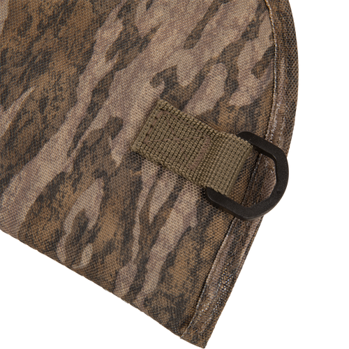 Close-up of The Migrator Gun Case's camouflage fabric with an olive-drab loop and D-ring, highlighting its durable, waterproof design for professional field use.