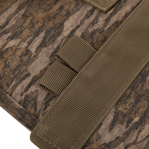 The Migrator Gun Case features camouflage fabric with olive-drab nylon webbing, showcasing MOLLE-style attachment points, ideal for durable, waterproof firearm protection.