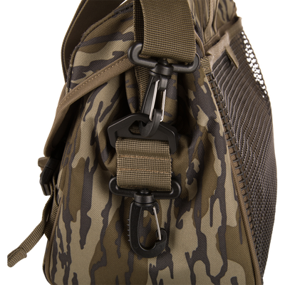 Hardline Shoulder Blind Bag with camo pattern, featuring heavy-woven nylon webbing strap, black D-ring, metal carabiner, and mesh pocket panel for waterfowl hunting essentials.