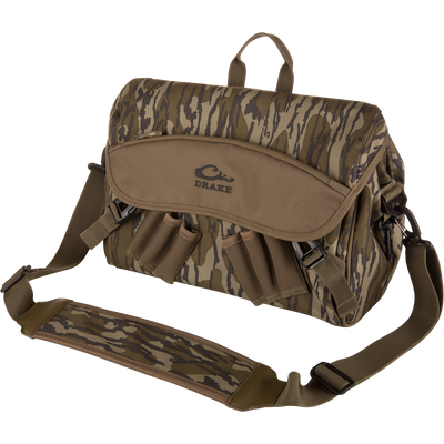 Drake's Hardline Shoulder Blind Bag, camo-patterned, soft-sided with adjustable strap, front flap, zipper pocket, and external loops, ideal for carrying hunting gear.
