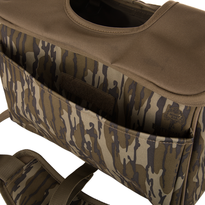 Close-up of the Hardline Blind Bag, camo-patterned with stitched nylon, external pockets, Velcro flap, and shoulder strap, designed for waterfowl hunting durability and weather protection.